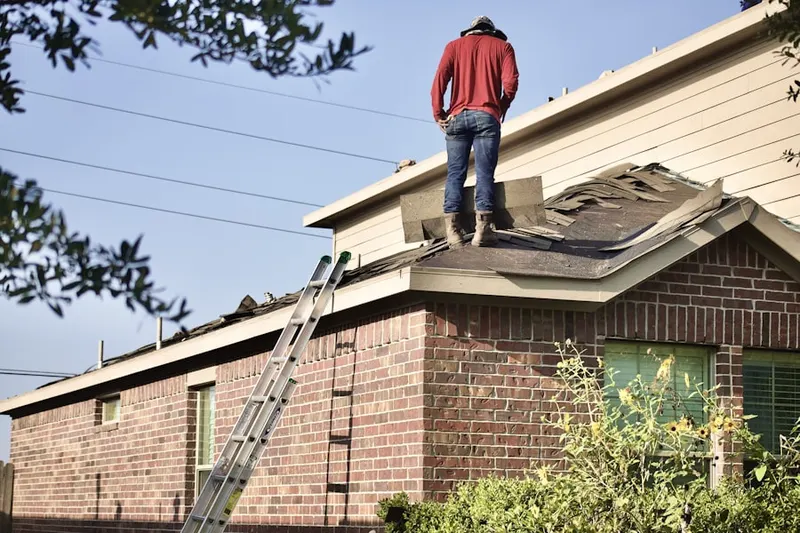 Professional roofer working on a residential roof in Sherman Park